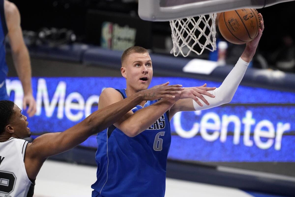 San Antonio Spurs forward Rudy Gay, left, defends against a shot by Dallas Mavericks center Kristaps Porzingis.