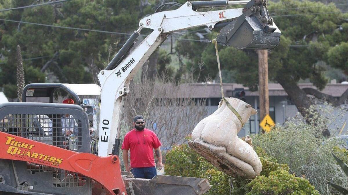 Half of one of the “kneeling women” statues is removed from the front of the Laguna College of Art + Design on Laguna Canyon Road on Wednesday. The two statues had been there for about 10 years and will be replaced with new artwork.