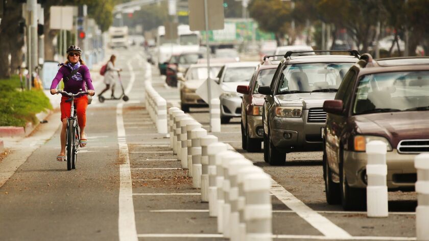 Cyclists navigate the westbound lanes of the Venice Boulevard bike lane in Mar Vista on Tuesday. The bike lane ignited controversy after city officials removed a lane of traffic to install it, creating a safer biking route but sparking some traffic delays.