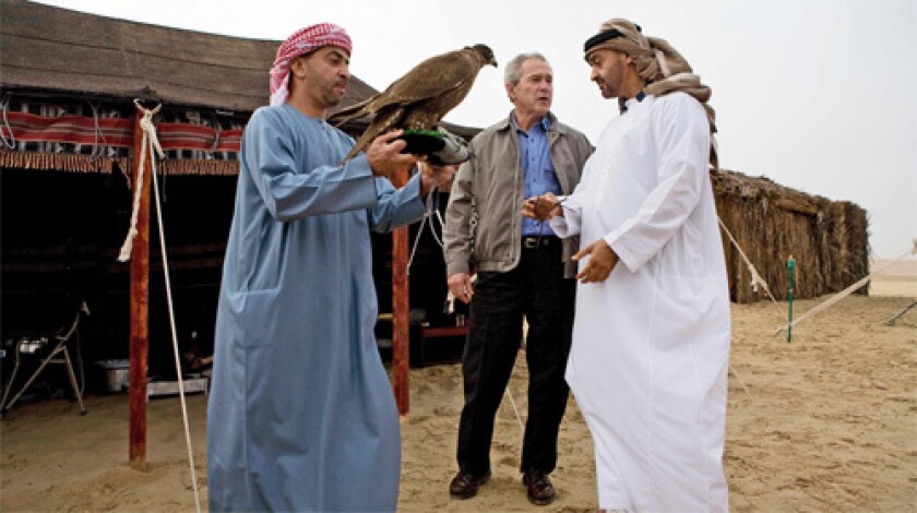 President Bush, center, chats with Abu Dhabi Crown Prince Sheikh Mohammed Bin Zayed al-Nahayan, right, ahead of a traditional dinner in the desert at the Royal Stables of the Al-Asayel Racing and Equestrian Club in Suwaihan.