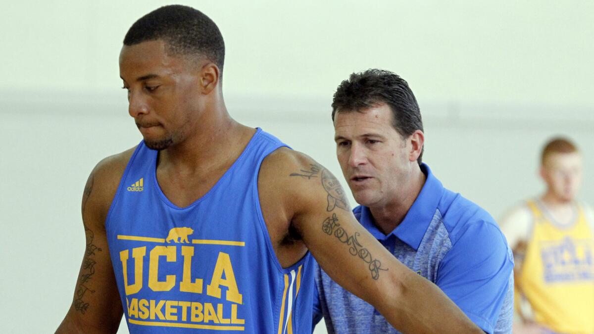 UCLA Coach Steve Alford, right, directs guard Norman Powell during a team practice session in October.