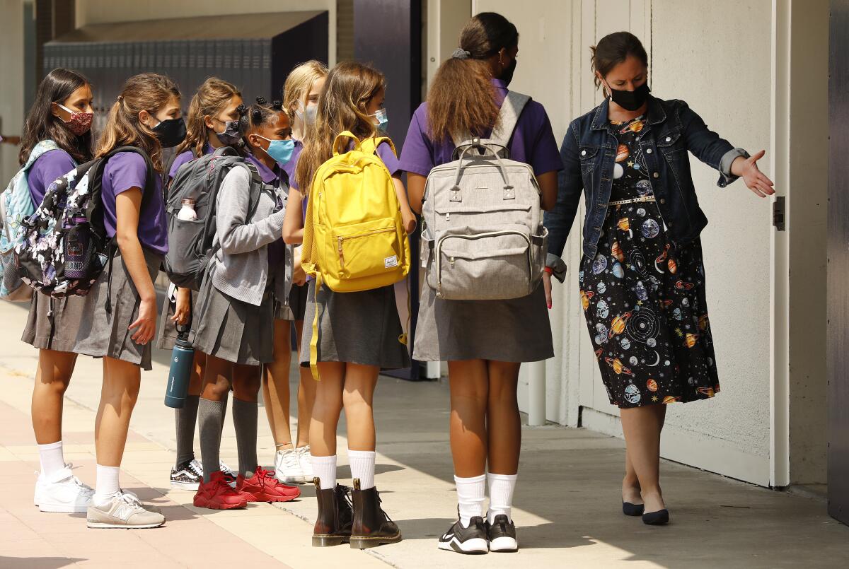 Sixth-grade teacher Kelsey McFadden directs students standing outside in an L.A. campus. 