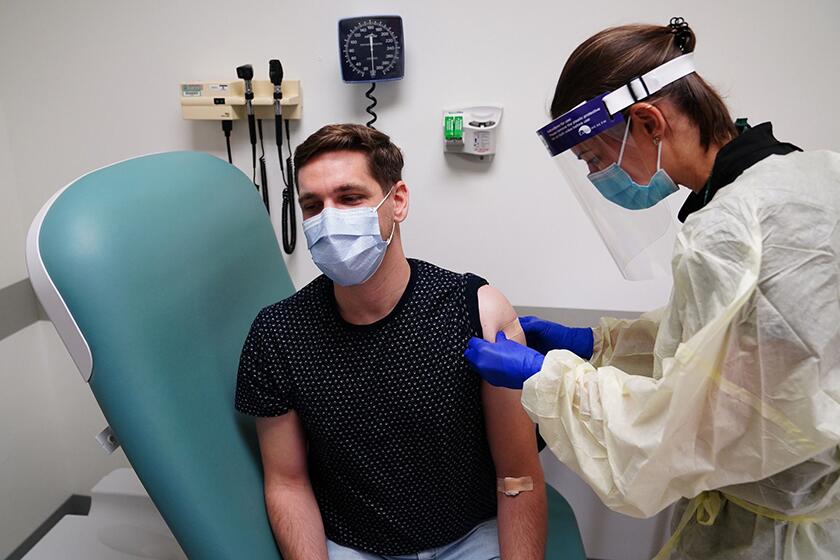 Clinical research nurse Samantha Gatewood gives Gregory Bowman a shot during a vaccine trial for AstraZeneca.