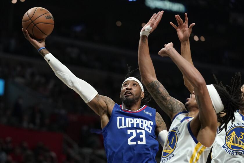 Los Angeles Clippers forward Robert Covington, left, shoots as Golden State Warriors guard Damion Lee defends during the second half of an NBA basketball game Monday, Feb. 14, 2022, in Los Angeles. (AP Photo/Mark J. Terrill)