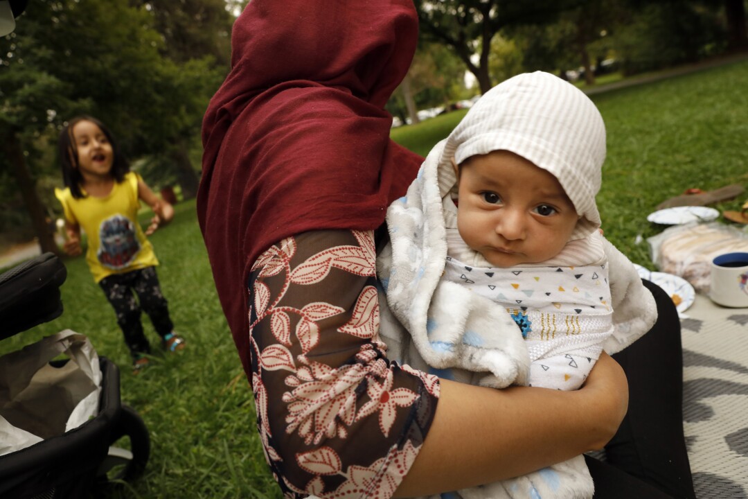 A month-old boy is cradled at the park.