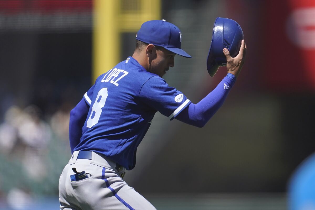 Kansas City Royals third baseman Nicky Lopez puts on the helmet of catcher MJ Melendez after catching a ball hit by San Francisco Giants' Brandon Crawford during the eighth inning of a baseball game in San Francisco, Wednesday, June 15, 2022. (AP Photo/Jeff Chiu)
