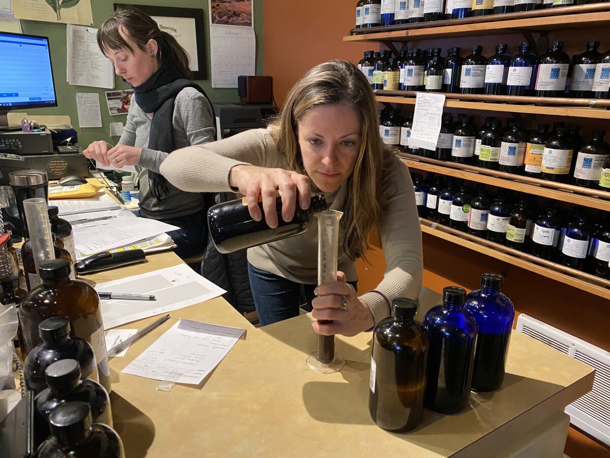 Katya Difani prepares a tincture Tuesday at her store, Herban Wellness in Kirkland, Wash. She says sales are booming as people stock up on natural sanitizers and herbal remedies.