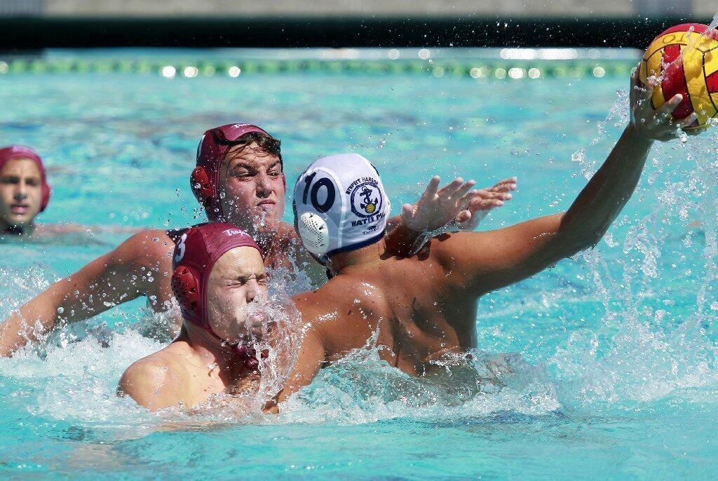 Makoto Kenney (10) of Newport Beach Water Polo is double teamed by Trojan's James Sweet, bottom, and Kyehl Vigille during the second half in the USA Junior Olympics 14U boys' bronze match at the William Woollett Aquatic Center in Irvine on Tuesday.