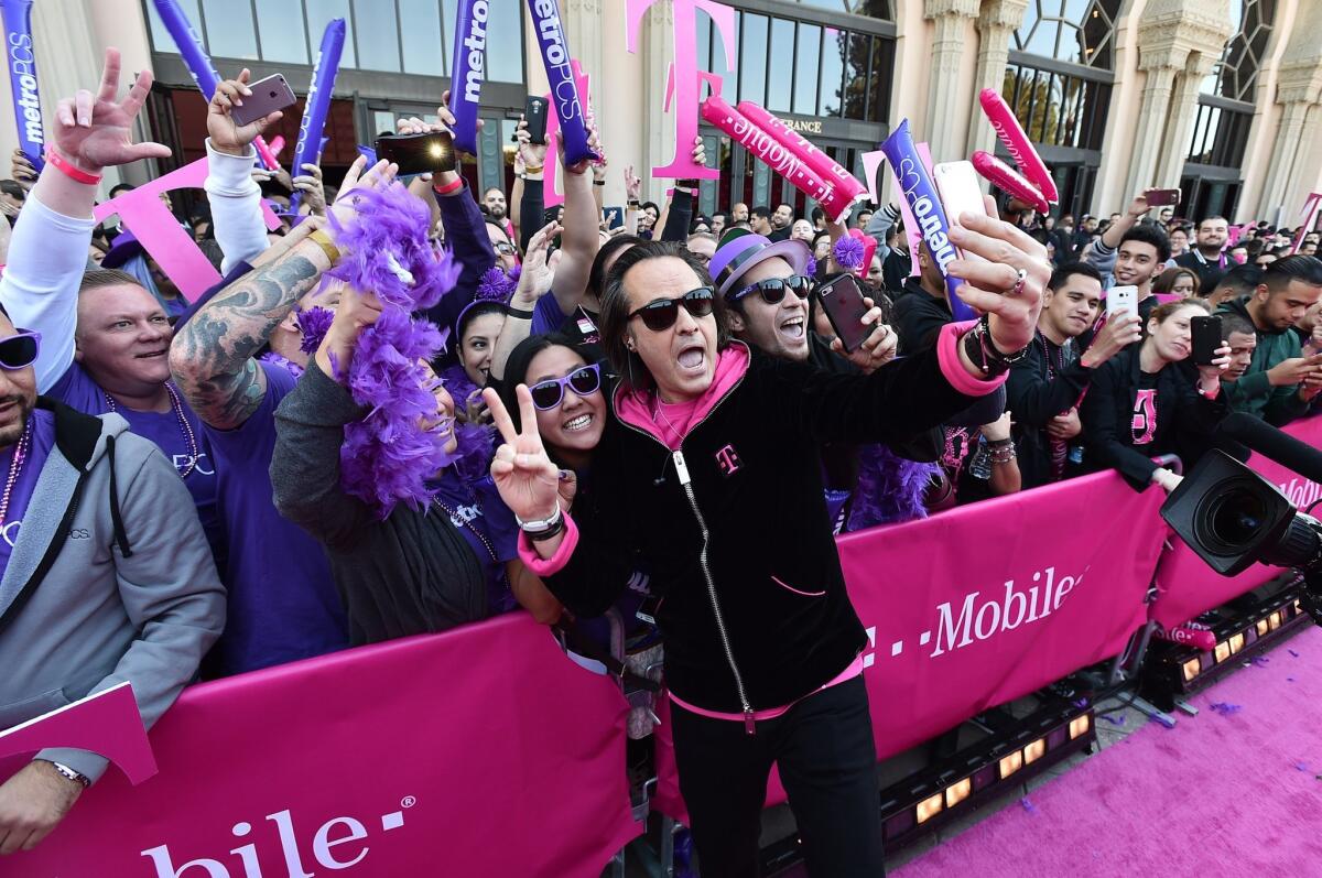You may think he's on your side, but he's not: T-Mobile CEO John Legere takes a selfie at the company's Los Angeles event on Nov. 10.