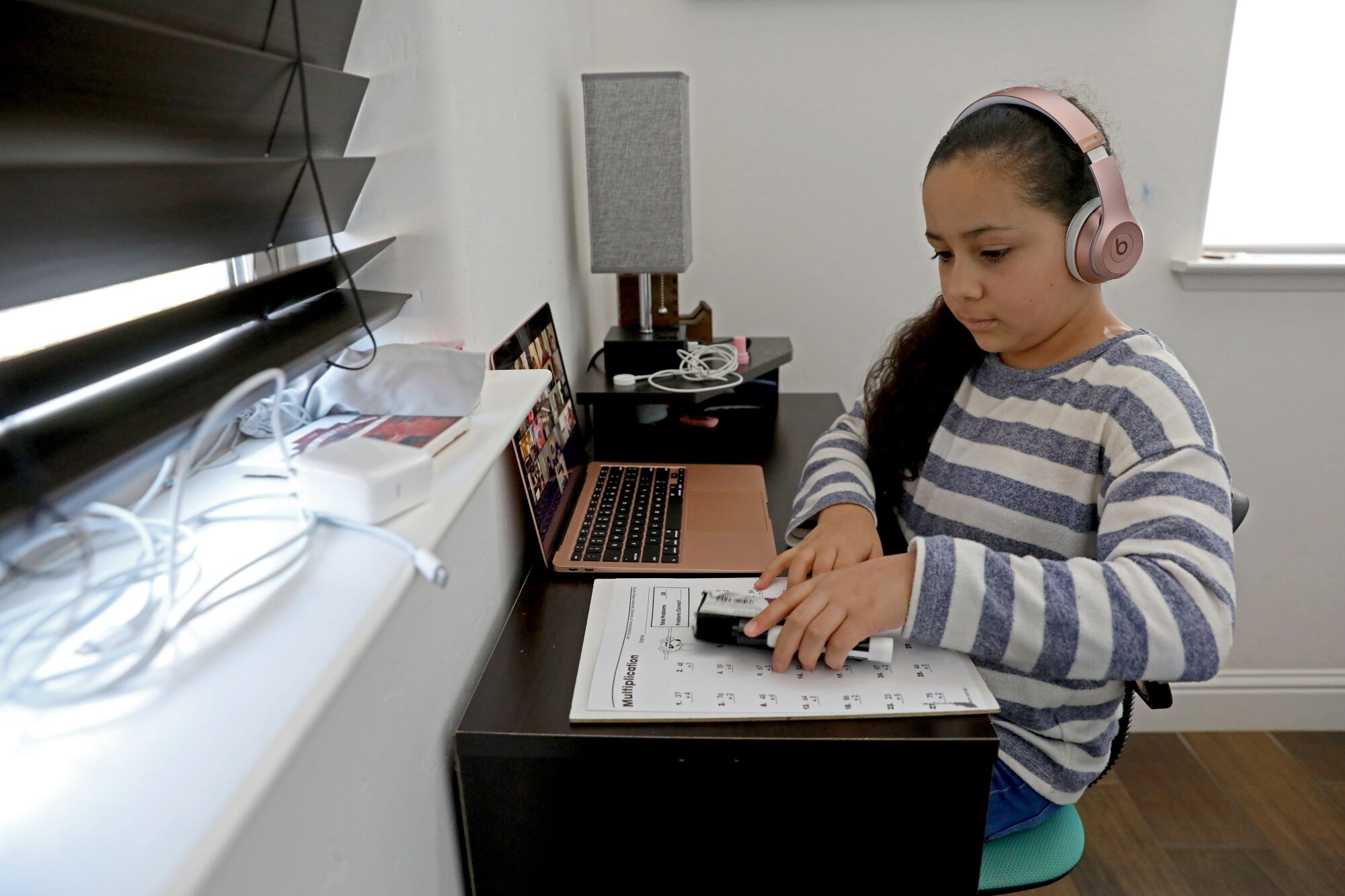 Sammi Ramirez, 8, third-grade, gets her supplies ready for an online class at her home in Fresno.