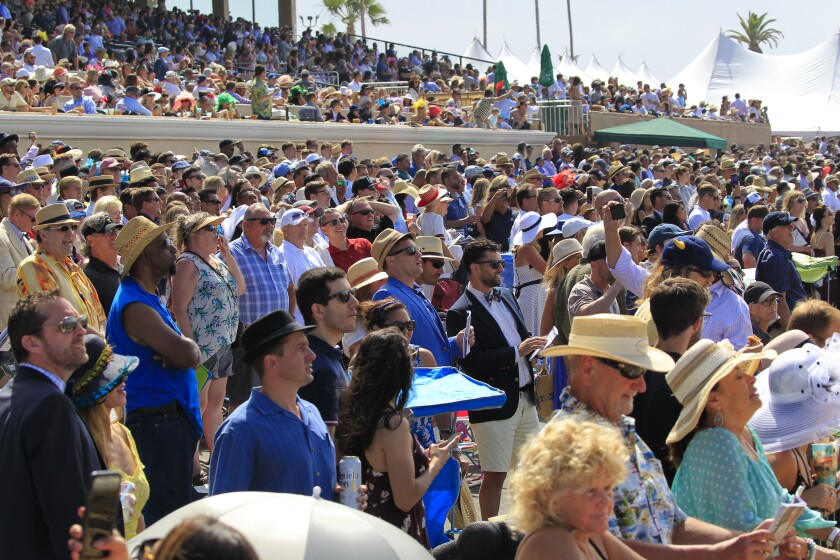 Race fans cheer for their horse on opening day this year at Del Mar Racetrack.