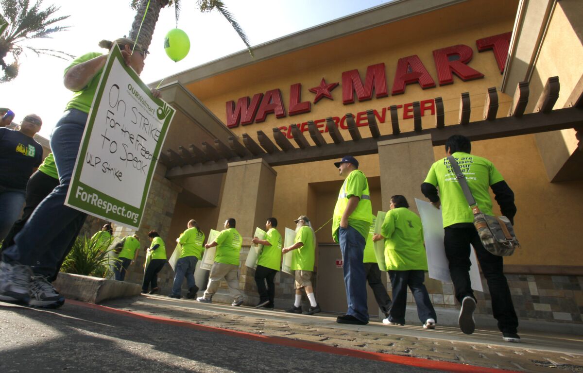 Workers protest wages and working conditions at the Pico Rivera Wal-Mart in 2012. The company is reopening the store, which has been closed for five months.