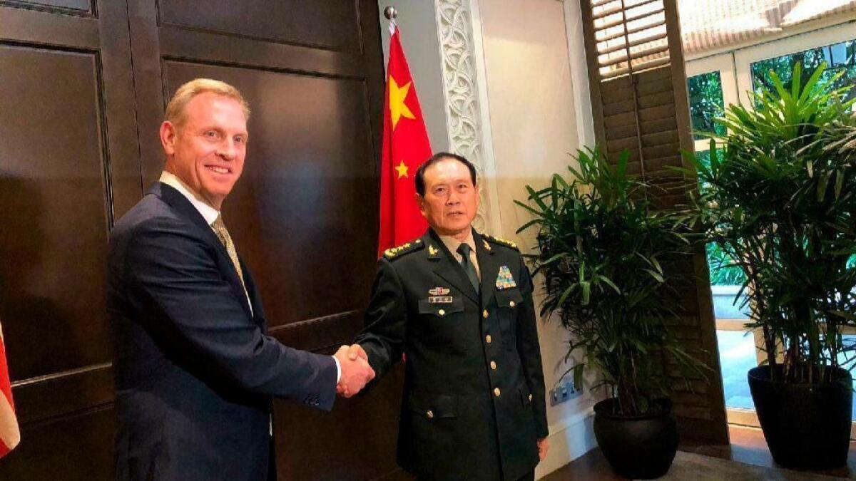 Acting U.S. Defense Secretary Patrick Shanahan, left, shakes hands with Chinese Defense Minister Wei Fenghe during a meeting on the sidelines of the 18th Shangri-La Dialogue in Singapore.