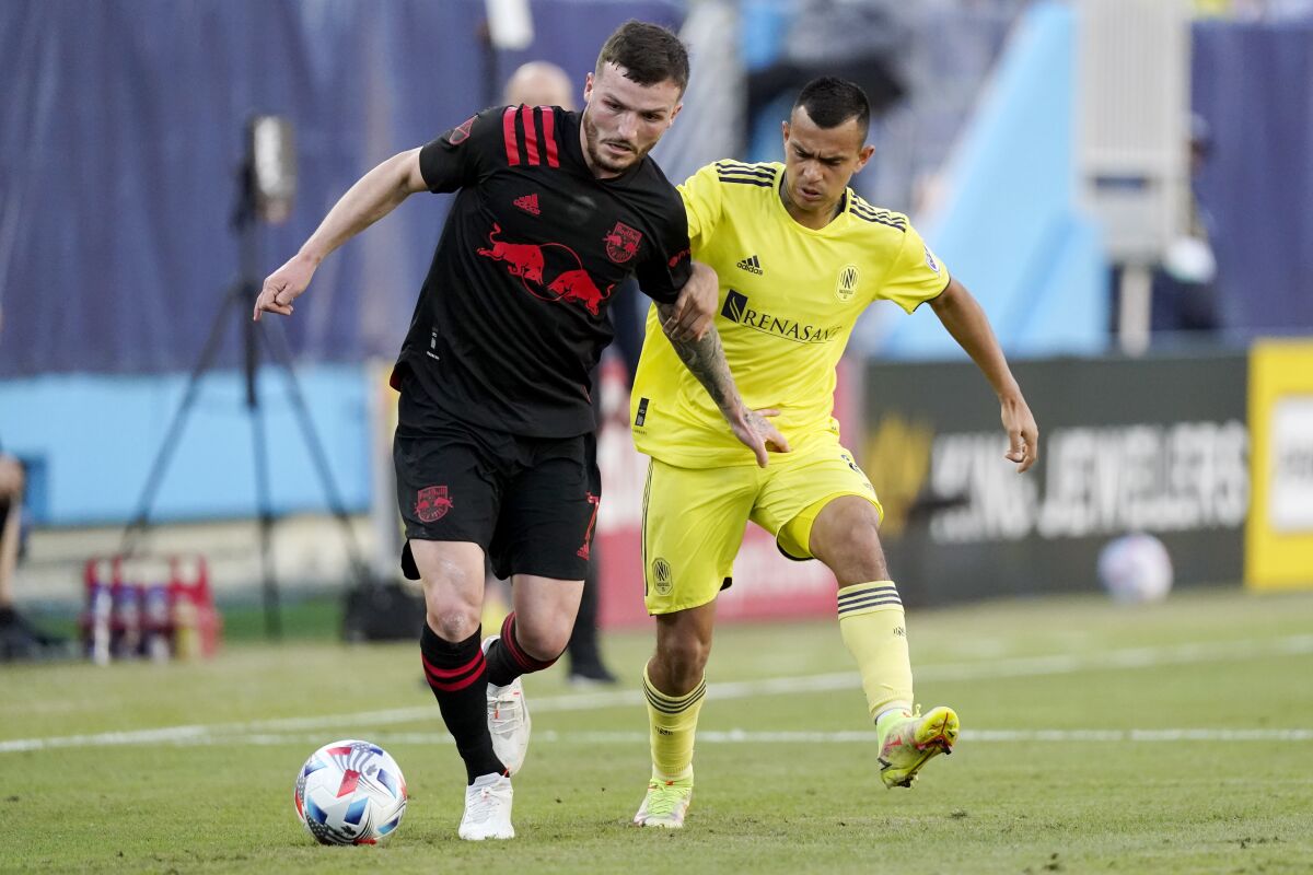 New York Red Bulls defender Tom Edwards (7) and Nashville SC midfielder Randall Leal (8) chase down the ball in the first half of an MLS soccer match Sunday, Nov. 7, 2021, in Nashville, Tenn. (AP Photo/Mark Humphrey)