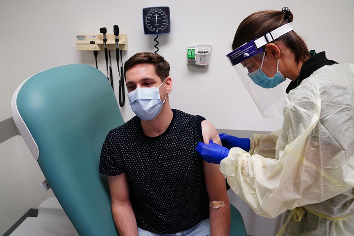 Clinical research nurse Samantha Gatewood gives Gregory Bowman a shot during a COVID-19 vaccine trial for AstraZeneca.