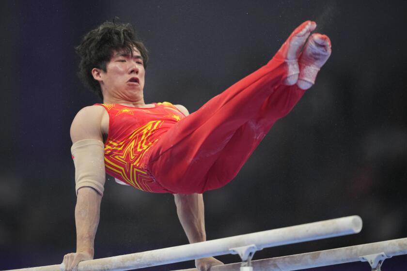 Zhang Boheng of China competes on the parallel bars during the men's all-around individuals gymnastics event of the 19th Asian Games in Hangzhou, China, Tuesday, Sept. 26, 2023. (AP Photo/Aaron Favila)