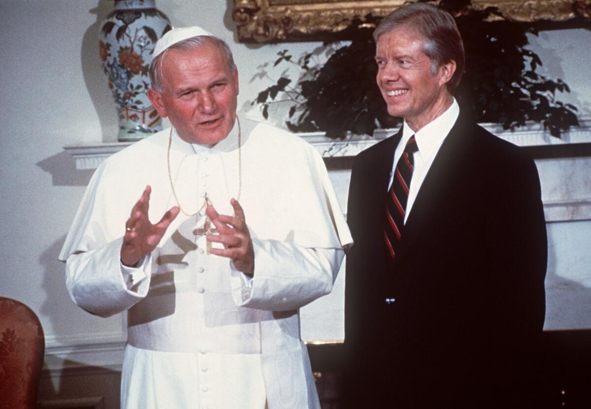 Pope John-Paul II (L) and former US President Jimmy Carter speaking to the media at the White House in Washington in October of 1979.