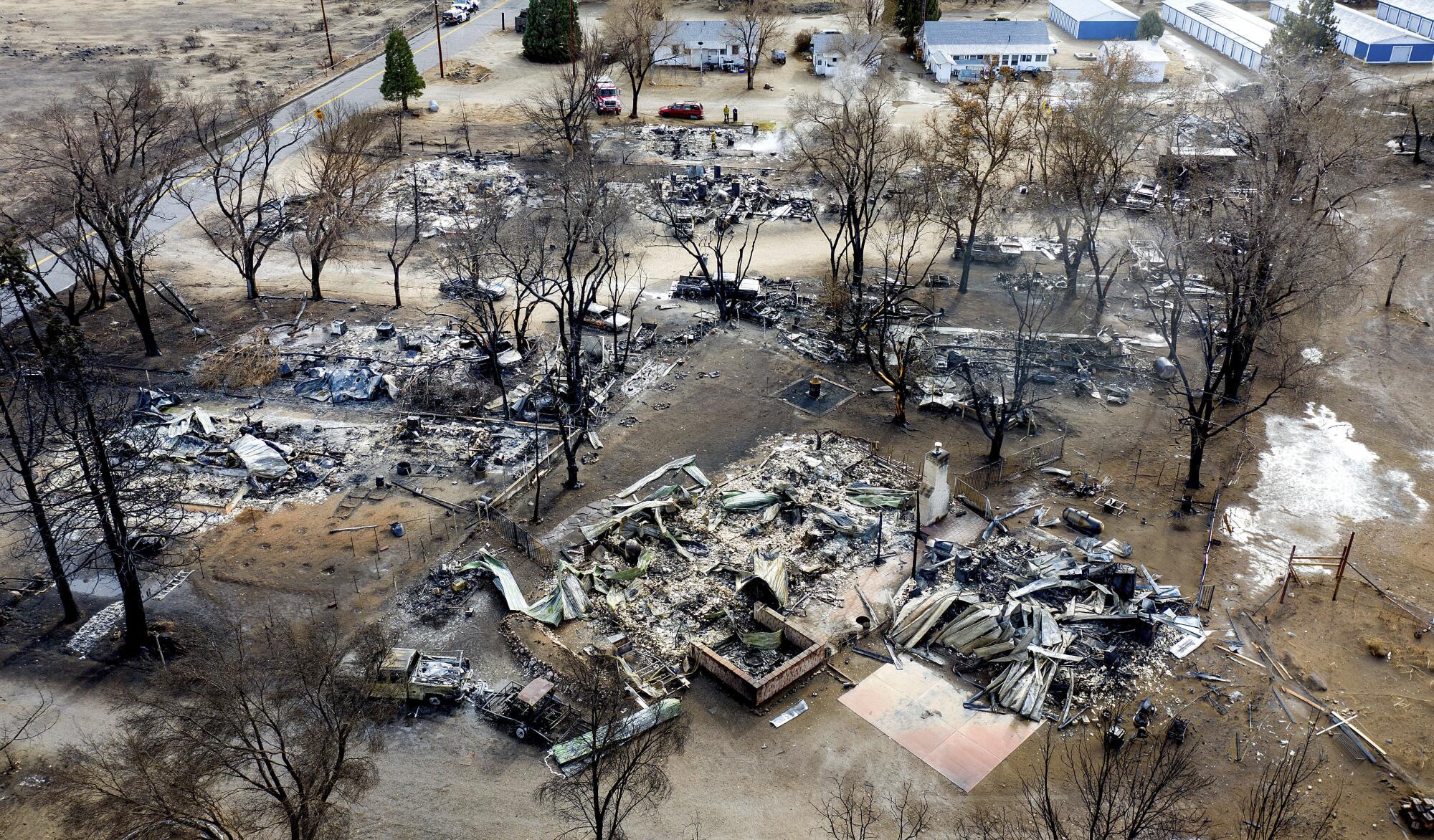 Aerial view of ash and smoldering wreckage of several homes