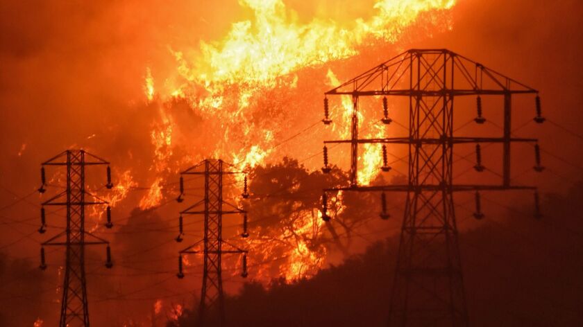 Flames burn near power lines in Montecito, Calif., on Dec. 16, 2017.
