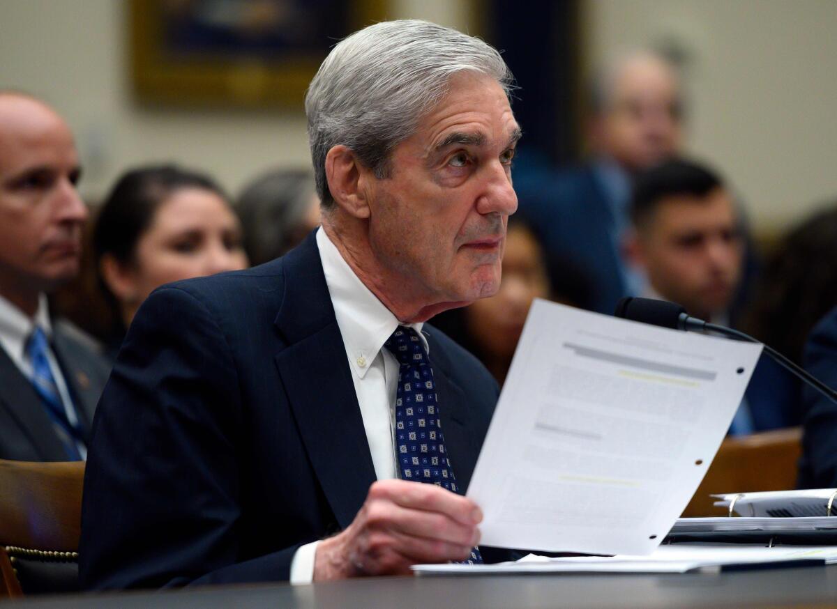 Former special counsel Robert S. Mueller III reads from his report as he testifies before Congress on Wednesday.