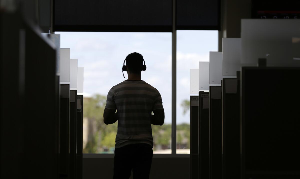 A man stands inside a call center 