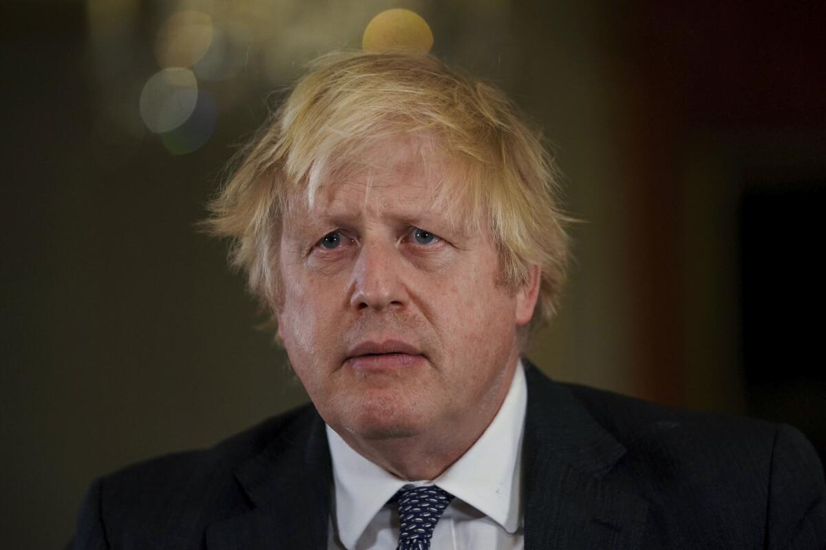 Boris Johnson in a suit looks on seriously