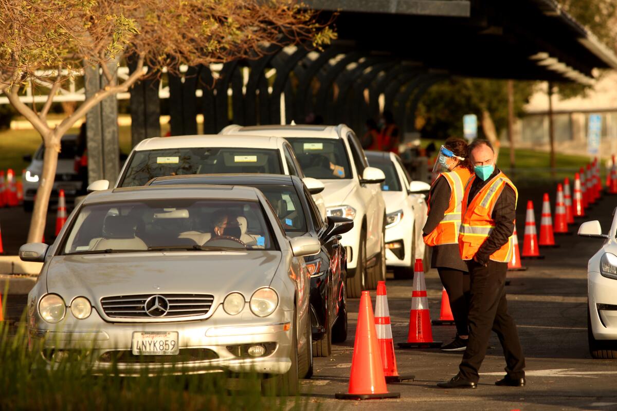 Motorists wait in their cars at a drive-through COVID-19 vaccination site at Cal State Northridge. 