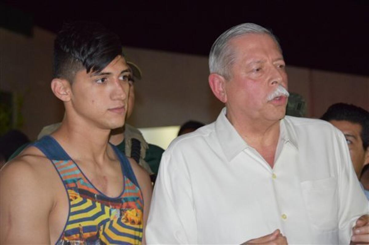 El delantero mexicano Alan Pulido (izquierda) comparece ante la prensa junto al gobernador del estado de Tamaulipas, en el norte del país, Egidio Torre Cantu, tras el rescate del futbolista, que pasó unas horas secuestrado, el 30 de mayo de 2016 en Ciudad Victoria, la capital del estado de Tamaulipas, en México. (AP Foto/Alfredo Pena)