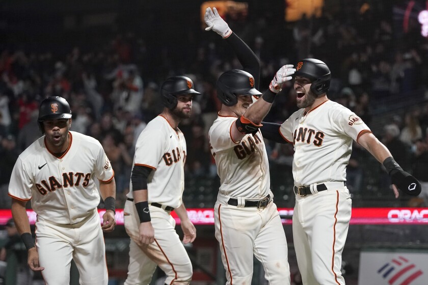 San Francisco Giants' Mike Yastrzemski, second from right, celebrates after hitting a grand slam home run that scored LaMonte Wade Jr., from left, Brandon Belt and Curt Casali during the eighth inning of a baseball game against the Arizona Diamondbacks in San Francisco, Tuesday, June 15, 2021. (AP Photo/Jeff Chiu)