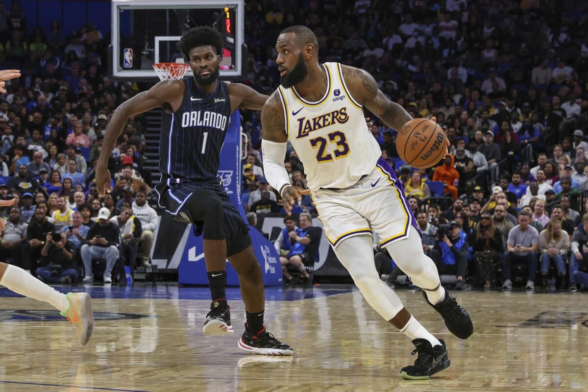 Lakers forward LeBron James (23) drives to the basket past Magic forward Jonathan Isaac.