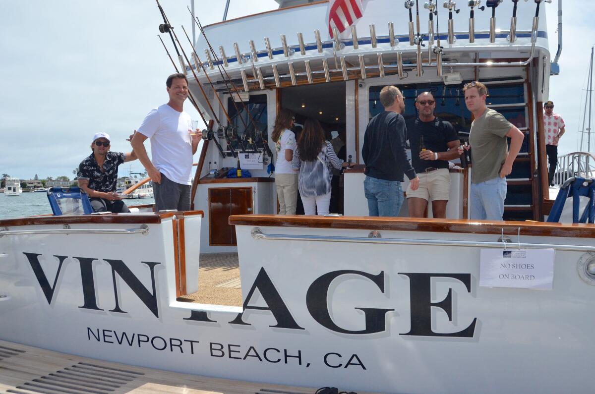Jason Armstrong, center, welcomes guests aboard his 65-foot, 1966 sport fishing boat, Vintage.