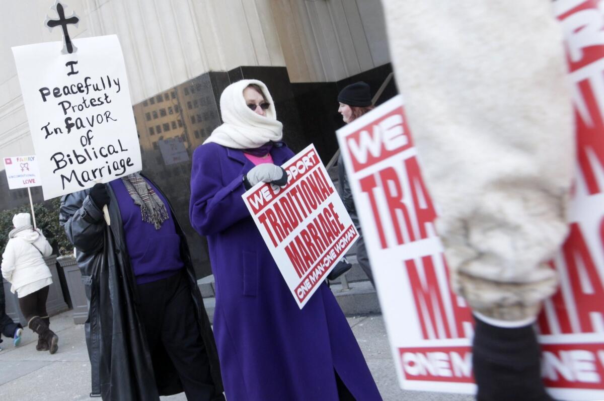 Protesters picket outside Federal Court in Detroit before a trial that could overturn Michigan's ban on gay marriage.