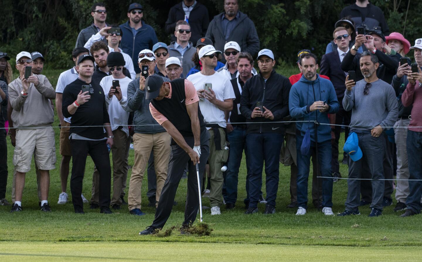 Tiger Woods hits out of the rough on the edge of the 18th fairway during the first round of the Genesis Invitational at Riviera Country Club on Feb. 13, 2020.