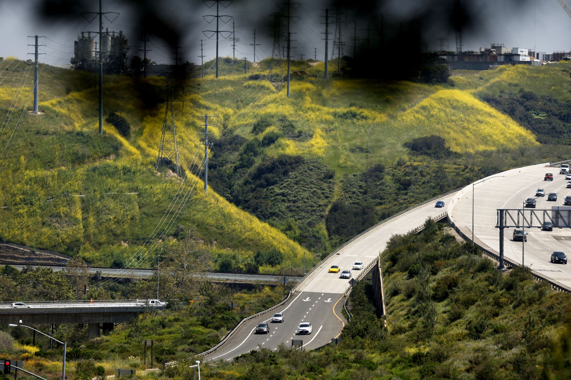Commuters exit northbound I-805 in Sorrento Valley surrounded by green and mustard covered hills. 