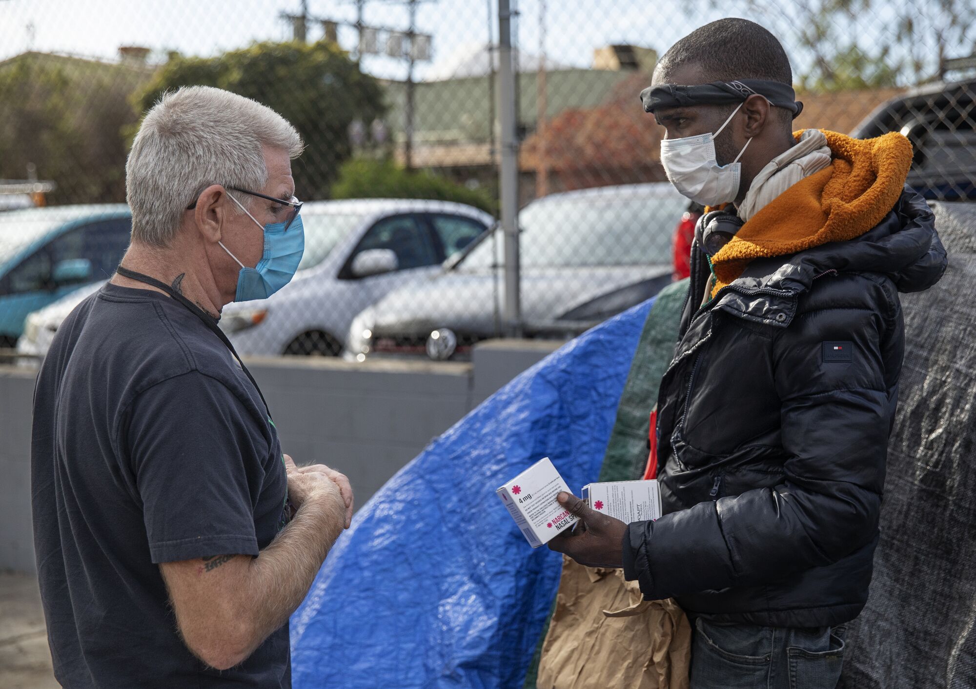 Jason Sodenkamp delivers supplies to Yatorion Jackson at a homeless encampment.