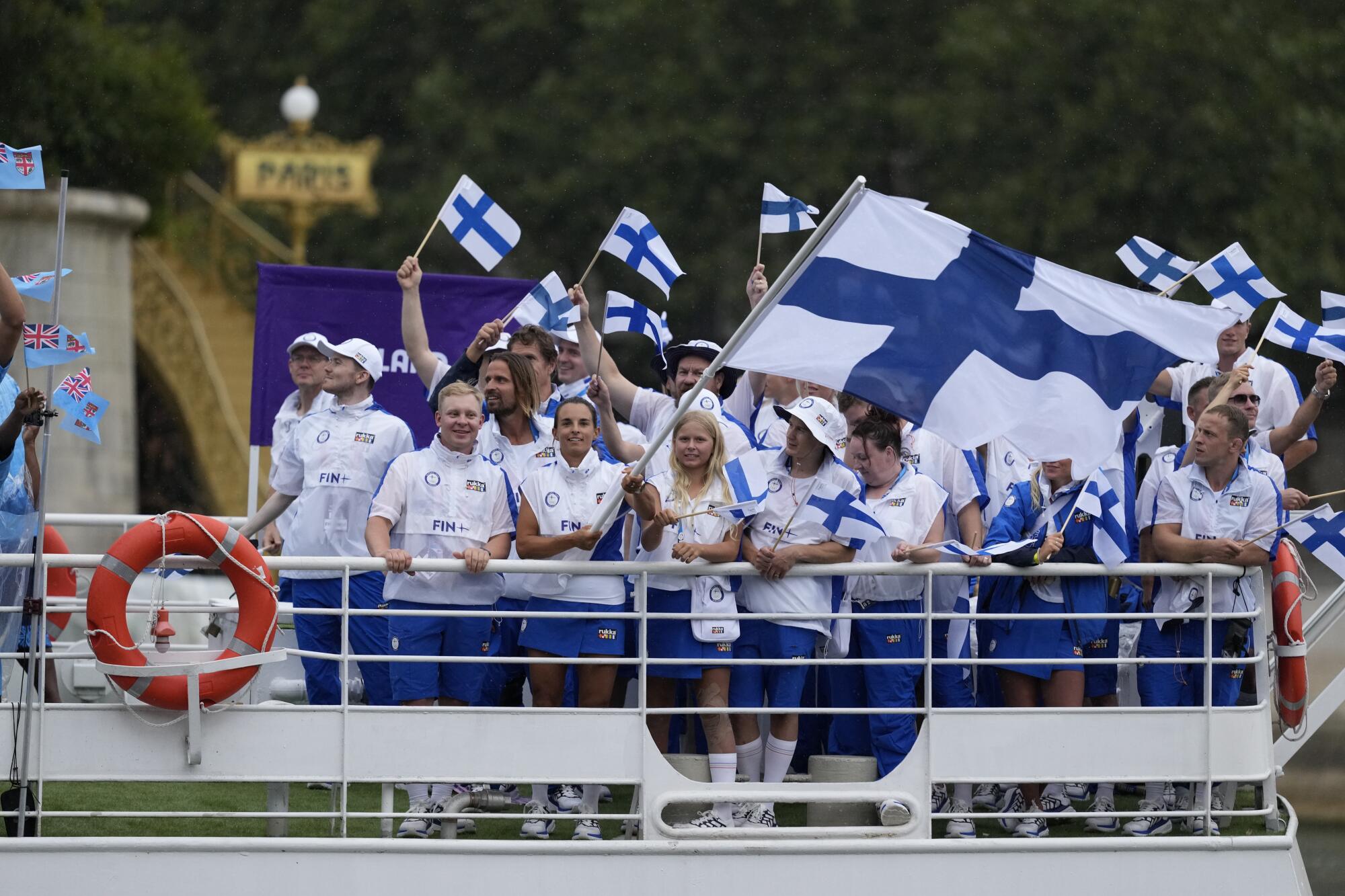 Finland's team parades along the Seine river in Paris, France, during the opening ceremony.