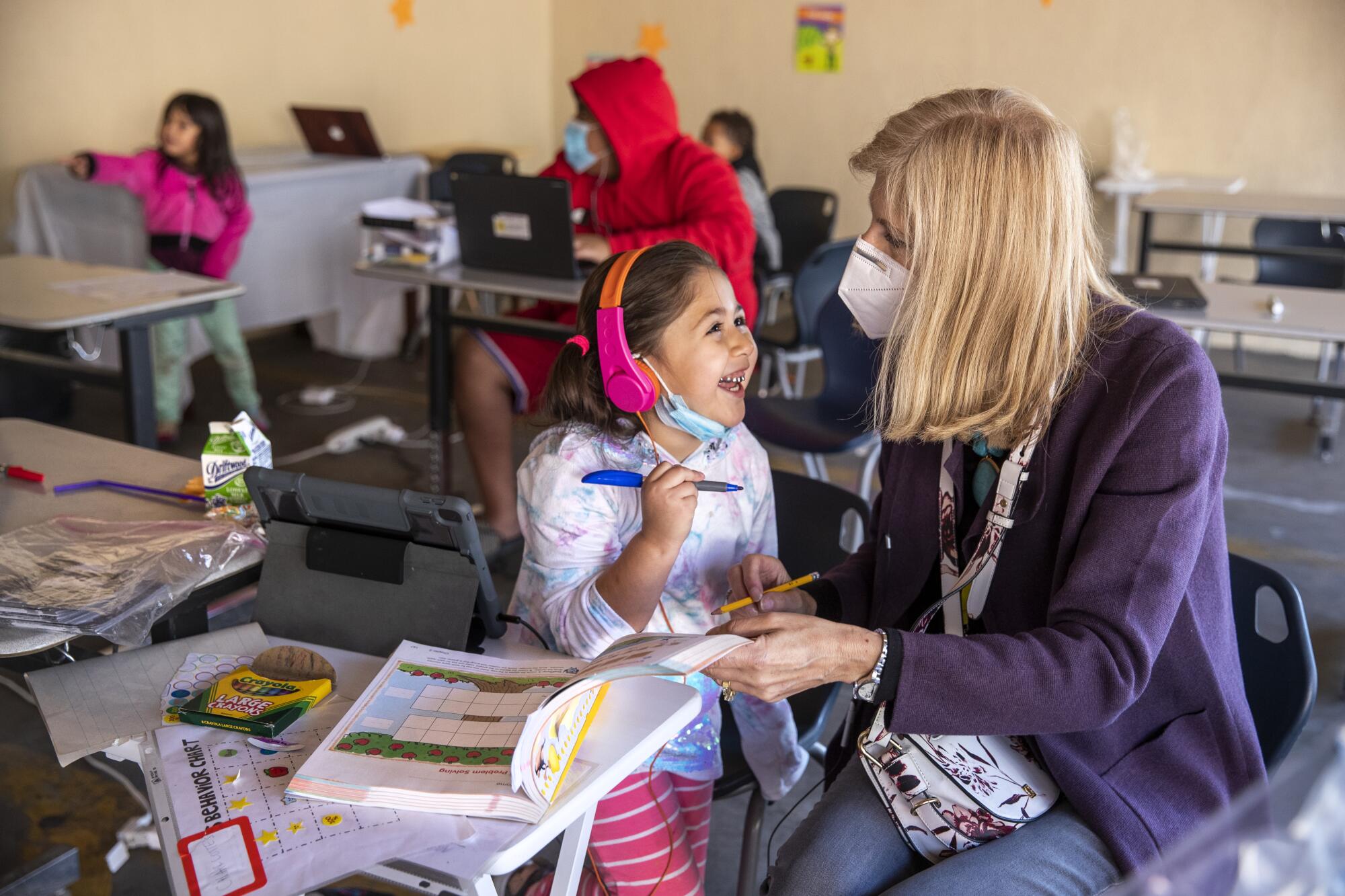 Volunteer Jill Ause helps a 5 year old kindergartner learn about sounds and the letters of the alphabet at a learning pod