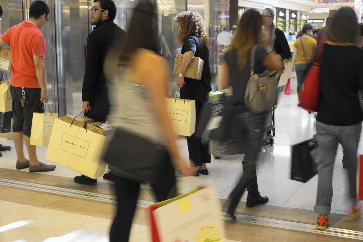 Total spending during the Black Friday shopping weekend was forecasted to drop to $50.9 billion, down from $57.4 billion last year. Above, shoppers scurry through South Coast Plaza in Costa Mesa on Black Friday.