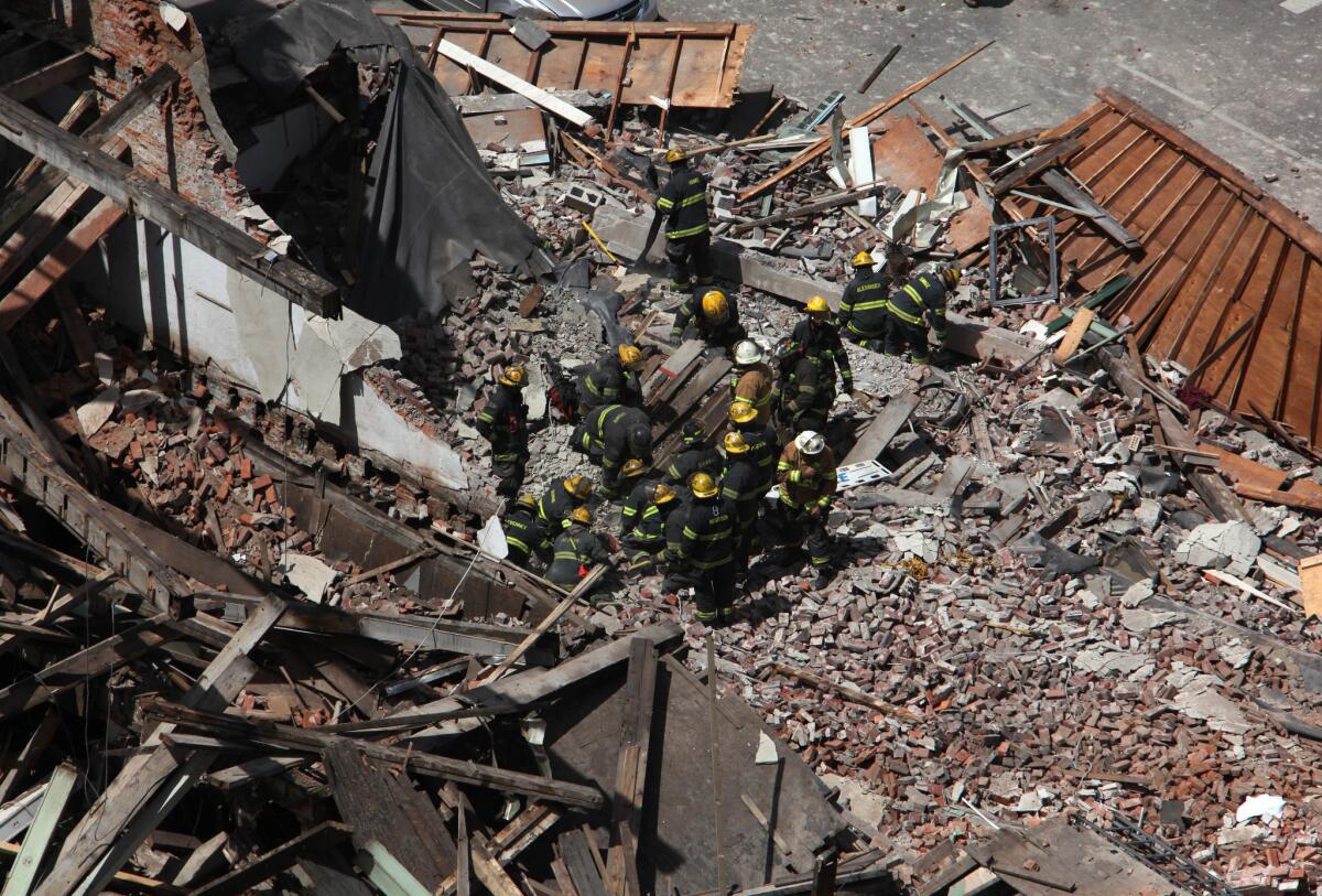Rescue personnel work at the scene of a collapsed four-story building in downtown Philadelphia on Wednesday. Twelve people were injured and two others are believed trapped beneath the rubble, the fire commissioner said.