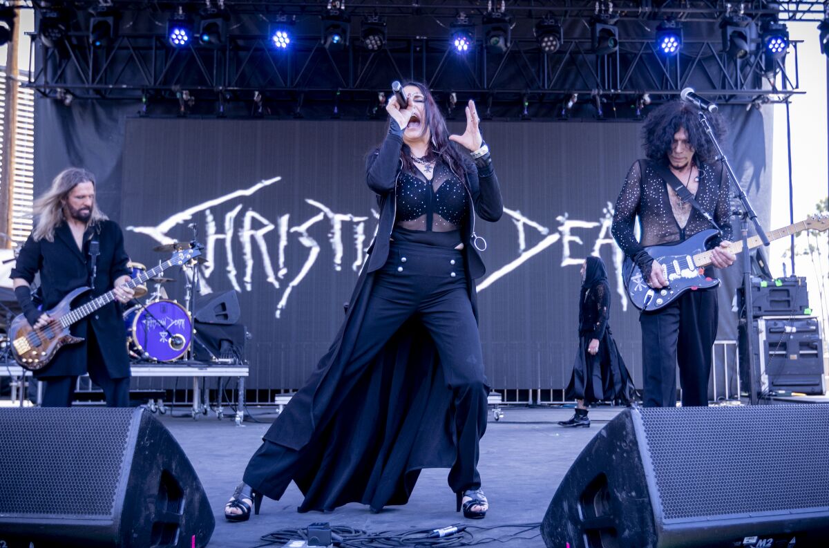 A band dressed in black performs onstage