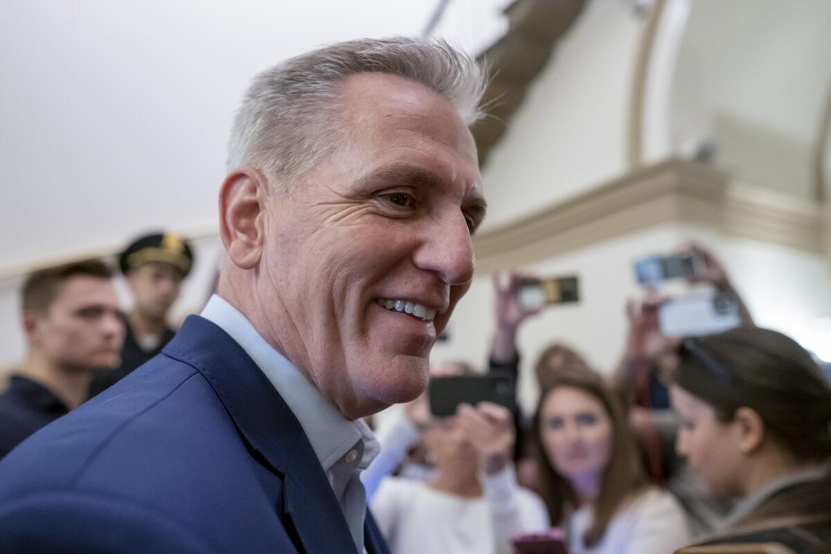 A man smiling amid reporters 