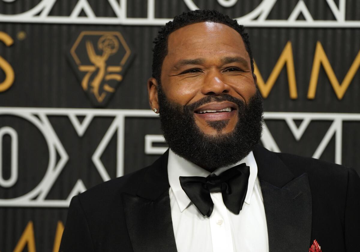 Anthony Anderson smiles while posing in a tuxedo