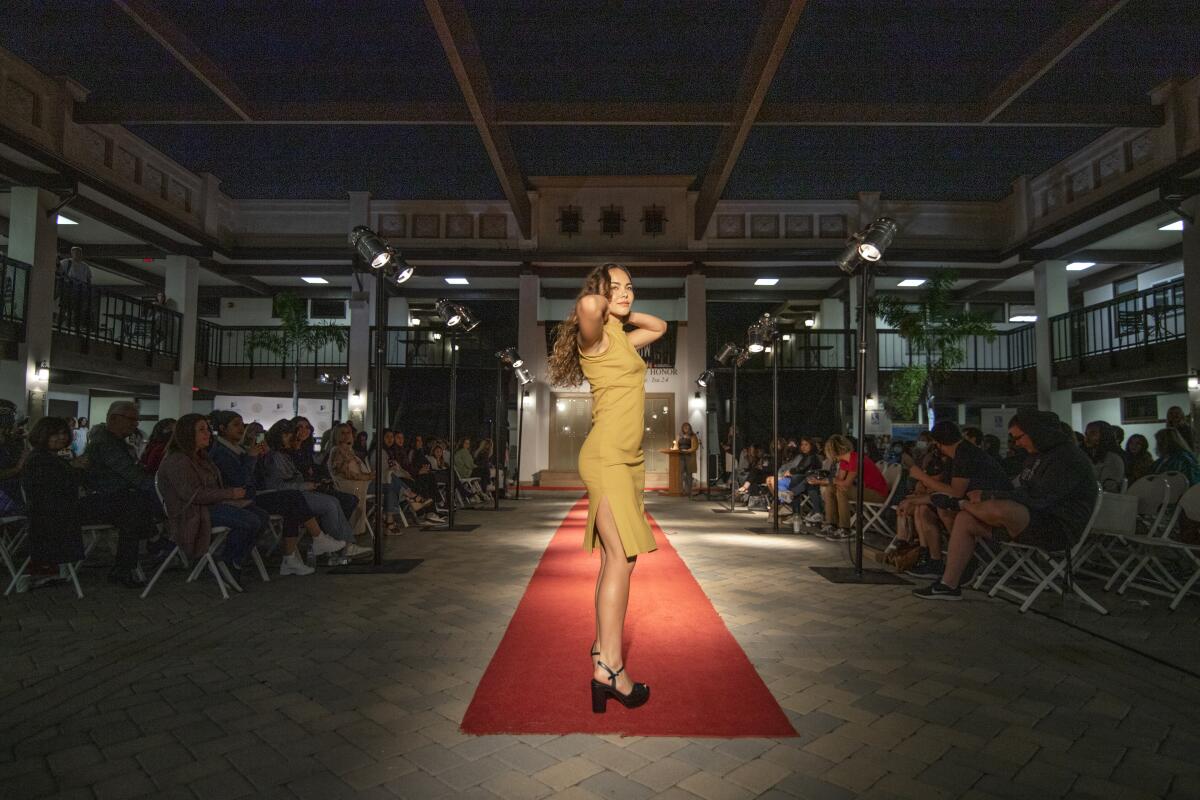 A model strikes a pose at a Vanguard University fashion show aimed at calling attention to the fast-fashion industry.