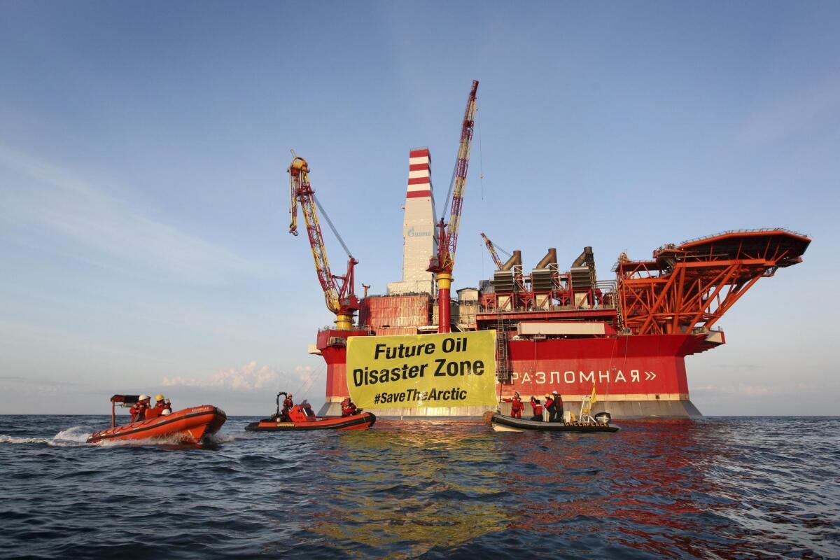 In this Aug. 25, 2012, file photo provided by Greenpeace, a banner unfurled by activists who scaled the Gazprom Prirazlomnaya oil-drilling platform in the Barents Sea warns of environmental disaster from exploitation of Arctic resources.