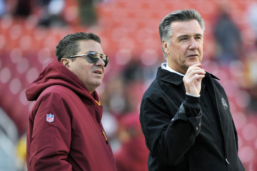 FILE - In this Oct. 21, 2018 file photo, Washington Redskins owner Dan Snyder, left, and team president Bruce Allen talk on the field prior to an NFL football game between the Dallas Cowboys and Washington Redskins, in Landover, Md. Allen was fired Monday, Dec. 30, 2019, after a tumultuous and loss-filled decade with the NFL team once coached by his father. (AP Photo/Mark Tenally, File)