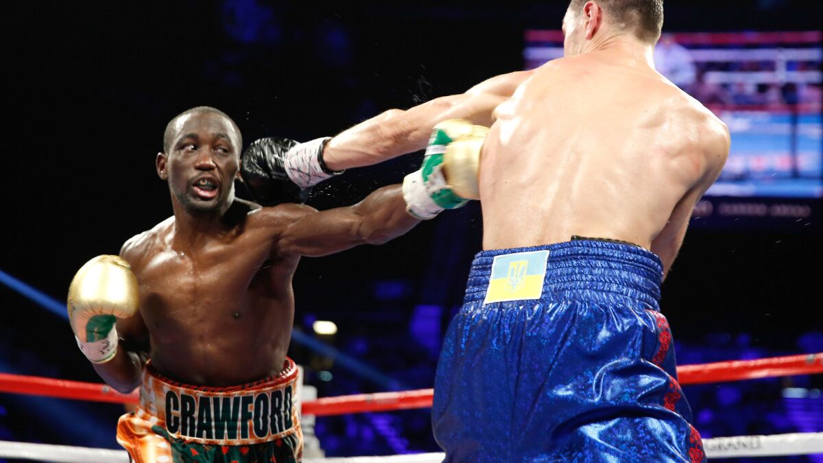 Terence Crawford, exchanges punches with Viktor Postal during their fight Friday night.