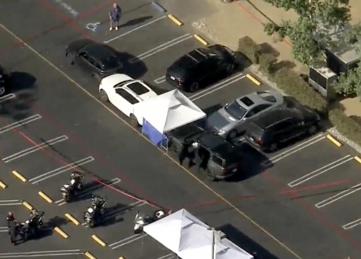 An aerial view of a parking lot with law enforcement vehicles and a tent.