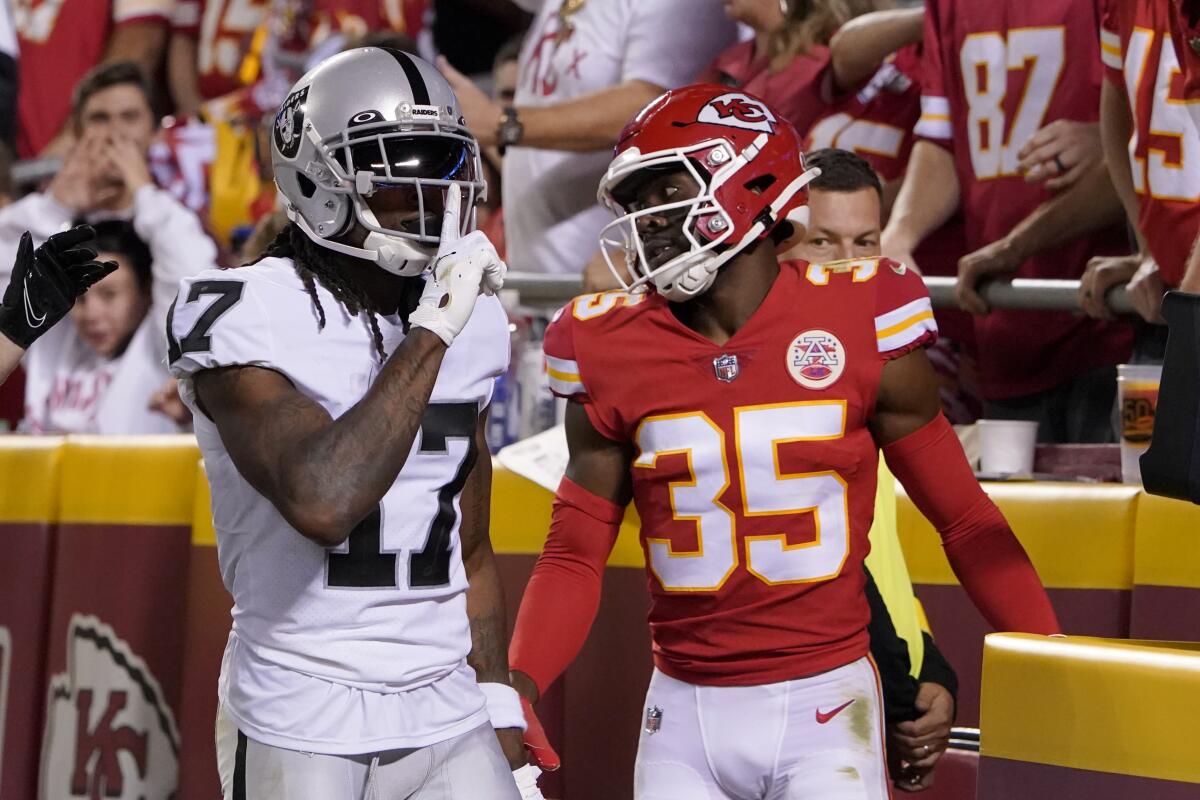 Raiders wide receiver Davante Adams puts his finger to his lips as Kansas City Chiefs cornerback Jaylen Watson watches