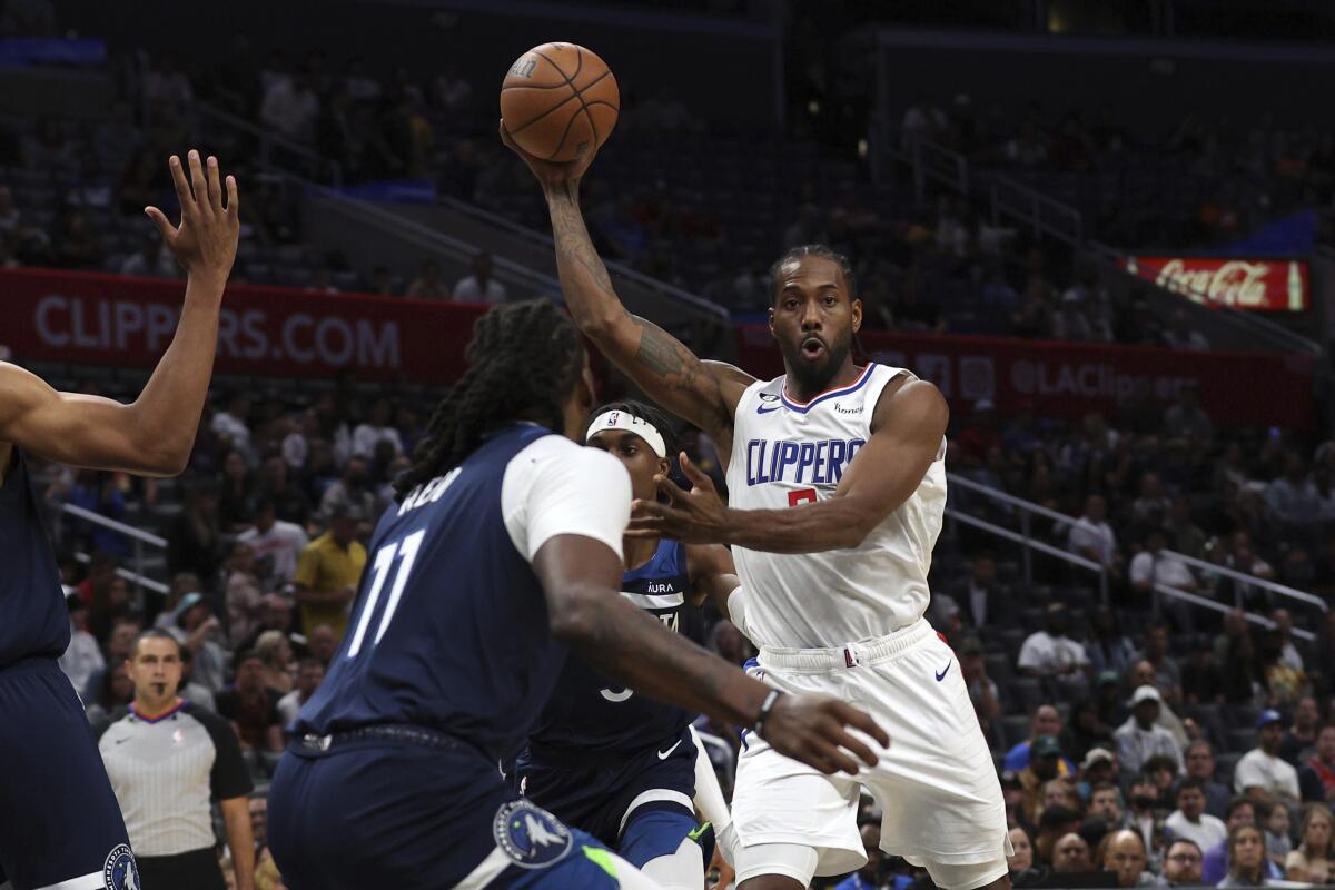 Los Angeles Clippers forward Kawhi Leonard, left, passes the ball against the Minnesota Timberwolves