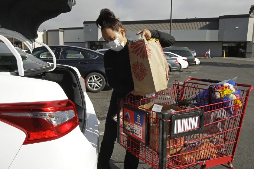 FILE - In this July 1, 2020 file photo, Instacart worker Saori Okawa loads groceries into her car for home delivery in San Leandro, Calif. Many new gig workers aren’t aware of the tax obligations associated with their new status as independent contractors. Delivery drivers, grocery runners and freelancers need to pay income and self-employment tax on their earnings, which can amount to 30% of their earnings. (AP Photo/Ben Margot, File)